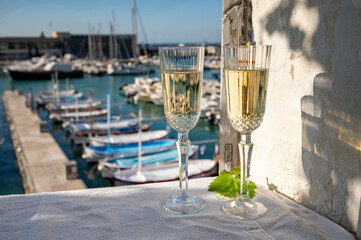 Obraz premium Birthday celebration with two glasses of French champagne sparkling wine and view on colorful fisherman's boats in old harbour in Cassis, Provence, France