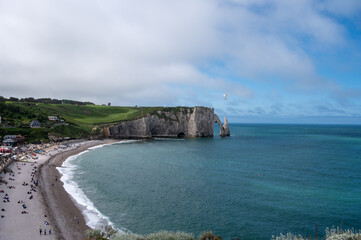 Fototapeta na wymiar Panoramic view on chalk cliffs and Porte d'Aval arch in Etretat, Normandy, France. Tourists destination.