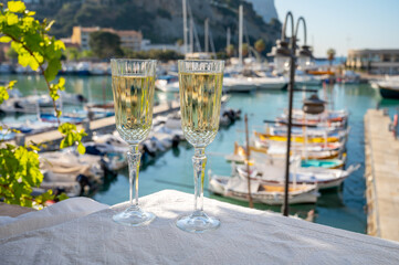Obraz premium Birthday celebration with two glasses of French champagne sparkling wine and view on colorful fisherman's boats in old harbour in Cassis, Provence, France