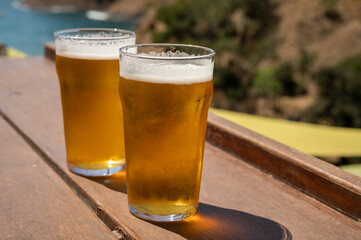 Two glasses of fresh cold lager beer served outdoor in snack bar with view on Calanque de Figuerolles in La Ciotat, Provence, France