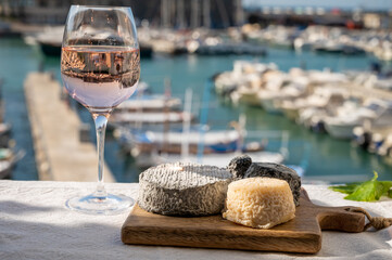 French goat cheeses crottin and selles-sur-cher served with view on boats in harbor of Cassis,...