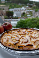 Tasty sweet French dessert, baked apple cake and view on old houses of Etretat, Normandy, France