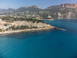 Obraz premium Panoramic aerial view on cliffs, blue sea, beach, houses, streets and old fisherman's harbour with lighthouse in Cassis, Provence, France