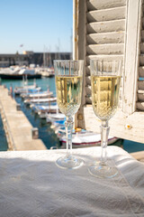 Two glasses of French champagne sparkling wine and view on colorful fisherman's boats in old harbour in Cassis, Provence, France