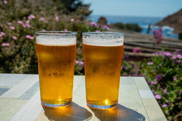 Two glasses of fresh cold lager beer served outdoor in snack bar with view on Calanque de Figuerolles in La Ciotat, Provence, France