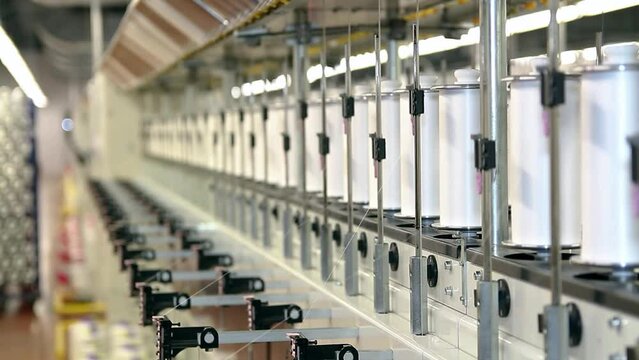 Textile Industry - Yarn Thread Running In The Machine. Automated Yarn Production In Modern Textile Plant. Cotton Yarn Making Machine.