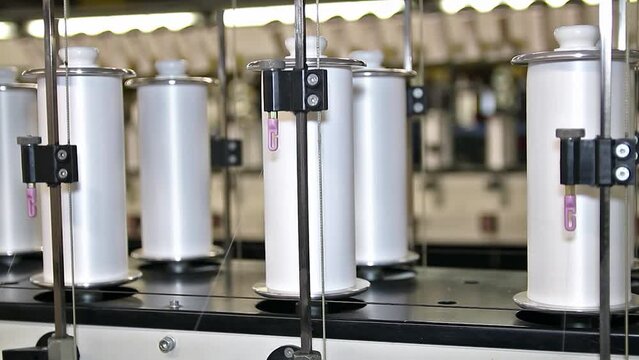 Cotton Yarn Production In A Textile Factory. Yarn Thread Running In The Machine. Production Of Yarn In The Textile Industry. Cotton Yarn Making Machine.
