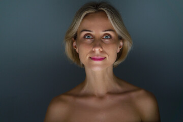 Fototapeta premium Blonde woman. No makeup. Grey background.