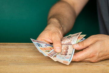 Guatemala money, a man in a shirt holds banknotes in his hands, counting money, financial...