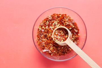 red chili pepper flakes on red background 