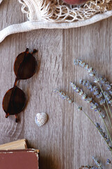 Sunglasses, vintage books, reusable mesh bag with fresh peaches, seashell and lavender flowers on wooden background Boho and rustic summery details, flat lay.