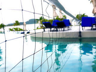 Detail of volleyball net over blue water swimming poo, Selective focus