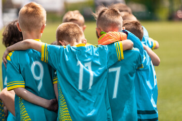 Youth sports coach witch children on soccer field. Kids huddling before the final tournament match....