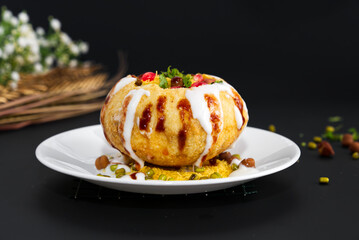 Raj Kachori - popular Indian chaat which crispy fried shells (kachori) filled with potatoes, boiled moong dal, yogurts, spices, chutneys and topped with various garnishes! - obrazy, fototapety, plakaty