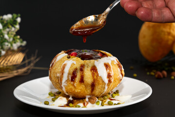 Raj Kachori - popular Indian chaat which crispy fried shells (kachori) filled with potatoes, boiled moong dal, yogurts, spices, chutneys and topped with various garnishes! - obrazy, fototapety, plakaty