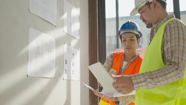 Asia architects and engineer planning of house renovation with blueprint indoor,home interior designer,working confliction,real estate development industries.