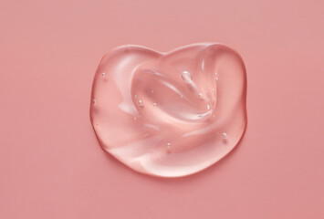 Cosmetic serum gel beauty drop on pink color background. Skincare beauty product with bubbles...