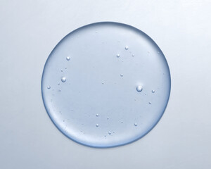 Cosmetic serum gel beauty drop on blue color background. Skincare beauty product with bubbles texture.
