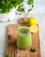 Green smoothie with pineapple, avocado, banana, parsley, lemon juice in a glass, sprinkled with chia seeds. Healthy dieting and nutrition, vegan und vegetarian concept.