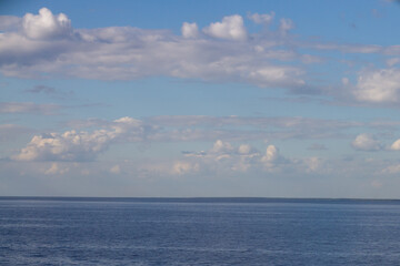 Naklejka na ściany i meble endless blue calm sea or lake with blue sky with white clouds