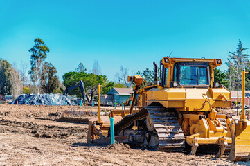 Fototapeta premium Close-up of a heavy bulldozer standing on a construction site. Preparation for construction.
