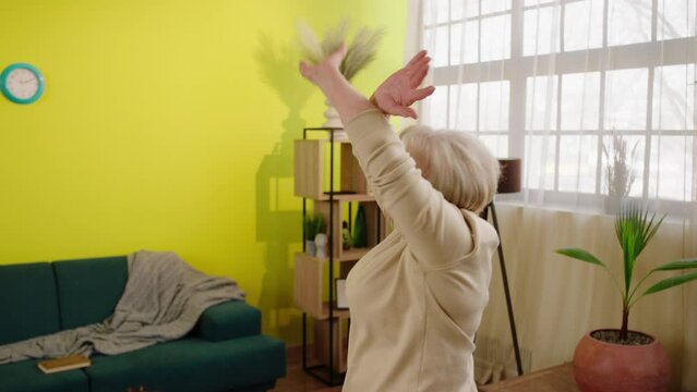 Excited And Charismatic Old Woman In Living Room Happy Dancing And Jumping While She Is Alone At Home She Have A Healthy Lifestyle