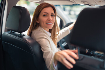 Fototapeta na wymiar Happy business woman driver sitting in car holding to steering wheel.