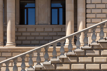 Building of classicism style with relief blocks, colonnade and stone staircase with balustrade