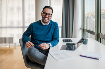 Portrait of confident smiling entrepreneur with laptop computer.