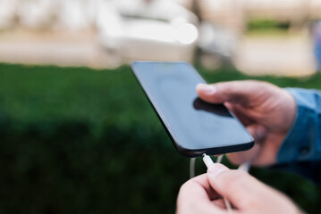 Man plugging-in his earphones at smartphone while preparing, listening to music