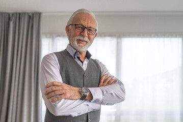 Smart mature businessman with glasses smiling and looking at camera.