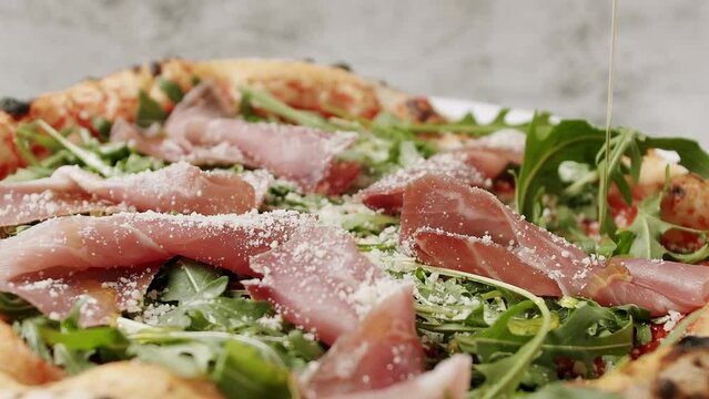 Prosciutto pizza with strachatella cheese, tomatoes, arugula leaves. Delicious Pizza with prosciutto parma ham, arugula salad rocket on white background with ingredients. Top view. Italian cuisine. 