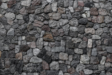 Great view of wall with masonry of various stones. Background and texture of stone wall surface