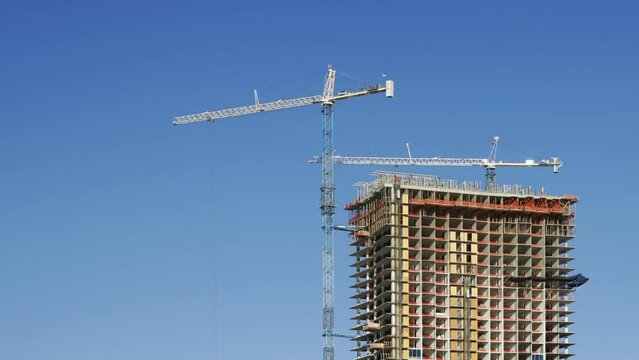 Time Lapse of construction cranes working on a new highrise.