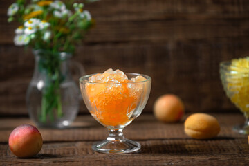 Summer Sicilian dessert granita, frozen fruit juice apricots, peaches, nectarines on a wooden background. Summer cooling, tonic cocktail of crushed ice, a kind of sherbet.