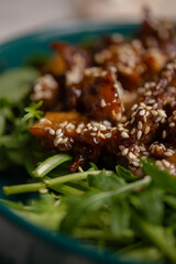 warm salad with mushrooms, sesame seeds and arugula close-up. macro