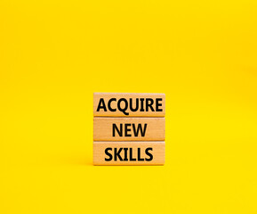Acquire new skills symbol. Concept words Acquire new skills on wooden blocks. Beautiful yellow background. Business and Acquire new skills concept. Copy space
