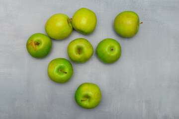 Still life photo of fresh green ripe apples on a grey rustic table. Still life food photography for many purposes