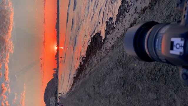  Video of a camera on a tripod taking pictures at sunrise on the beach, because it is the photography day.