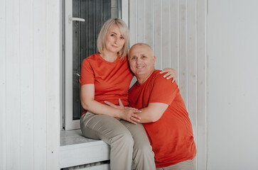 husband and wife in orange t-shirts hug and kiss