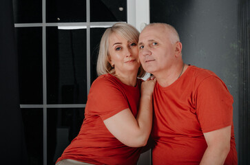 husband and wife in orange t-shirts hug and kiss