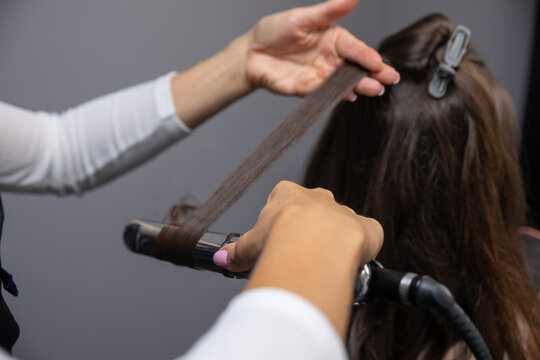 a hairdresser makes a woman's hair in a spa salon
