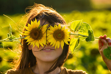 Girl in the yellow Sunflower Fields Young woman laughs with a sunflower on her face copy space