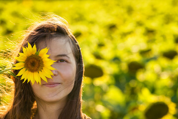 Girl in the yellow Sunflower Fields Young woman laughs with a sunflower on her face copy space