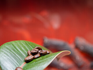 Coffee beans on a green leaf against the background of fire.