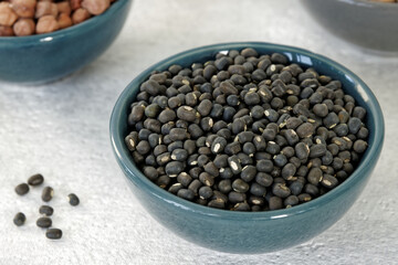 Dry Black lentil (urad sabut) seeds pile in a bowl.