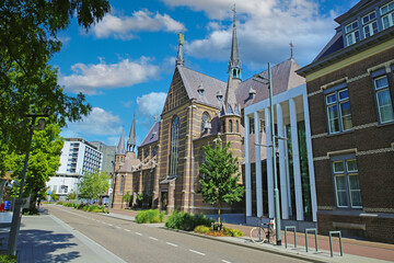 Eindhoven, Netherlands - July 17. 2022: City street with medieval gothic augustine church and...