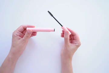 Girl hold mascara. Eyelash brush. Pink tube of mascara. Makeup cosmetics
