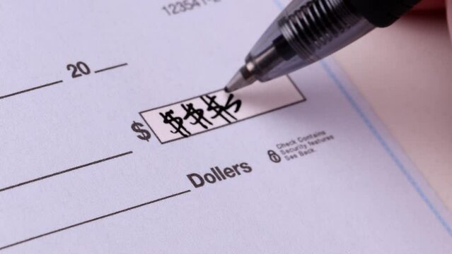 Close-up shot of a check being writen.