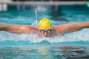 Close up male athlete swimming butterfly